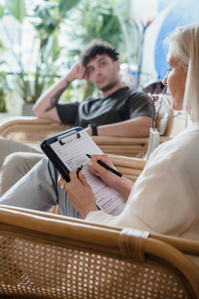 Therapist takes notes during a counseling session with a thoughtful client.